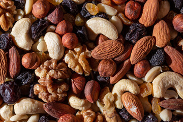 Mixed Nuts: Almonds, Walnuts, Cashews, Peanuts, Hazelnuts, Dried Prunes and Raisins. Different Nut Mix. Background from Various Nuts and Dried Fruits