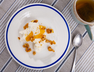 Delicious farm cottage cheese with honey and walnuts on a plate