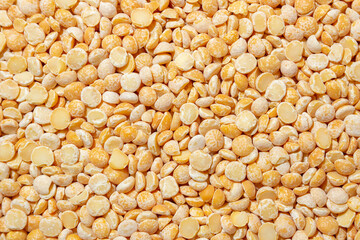 Uncooked Polished Split Peas Background. A Culinary Canvas of Dry Yellow Peas, Creating a Lively and Textured Background for Gourmet Cooking. Scattered Raw Polished Peas. Healthy Eating Ingredients