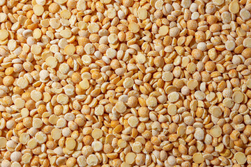 Uncooked Polished Split Peas Background. A Culinary Canvas of Dry Yellow Peas, Creating a Lively and Textured Background for Gourmet Cooking. Scattered Raw Polished Peas. Healthy Eating Ingredients