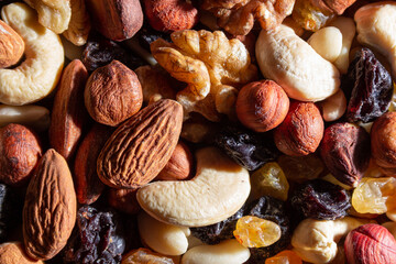 Mixed Nuts: Almonds, Walnuts, Cashews, Peanuts, Hazelnuts, Dried Prunes and Raisins. Different Nut Mix. Background from Various Nuts and Dried Fruits