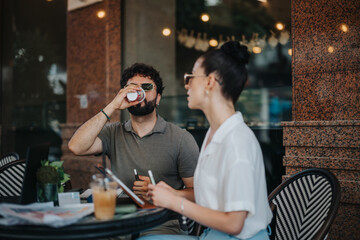 Two colleagues having a business meeting in a coffee shop, engaging in conversation and enjoying beverages while working together.