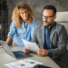 female colleague bring to male colleague document for signature