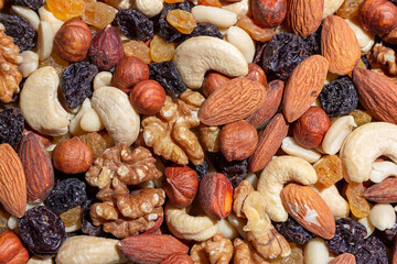 Mixed Nuts: Almonds, Walnuts, Cashews, Peanuts, Hazelnuts, Dried Prunes and Raisins. Different Nut Mix. Background from Various Nuts and Dried Fruits