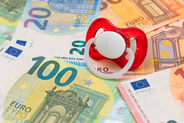Childfree, Contraception and Birth Control Concept: Baby Pacifier on the Euro Banknotes. Having Children is Expensive and Unprofitable