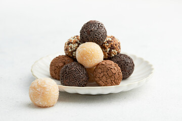 Typical Brazilian sweet brigadeiro. A heap of assorted flavors of candies on a white table