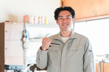 倉庫・作業場・工場にいる建築業・土木業の作業着姿の中年男性
