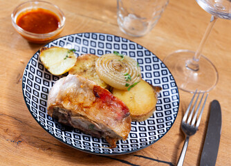 Delicious roasted leg of lamb with potatoes and onions served on platter