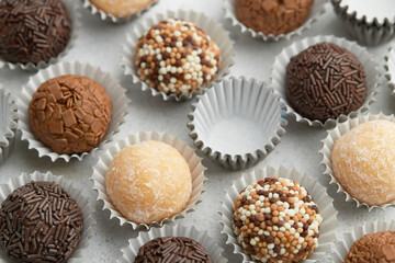 Typical Brazilian sweet brigadeiro. Top view of assorted flavors candies on a white table. Pattern