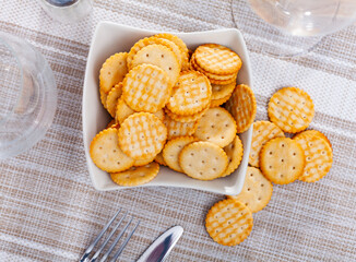 Delicious round crackers in a plate, placed on the table. Close-up image