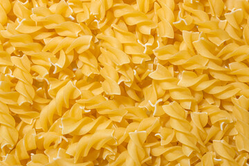 Uncooked Fusilli Pasta: A Culinary Canvas of Spiral Macaroni, Creating a Lively and Textured...