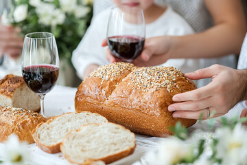 a Jewish family blessing the bread and wine during Shabbat.