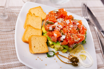 Delicious salmon tartare with avocado, arugula and lemon