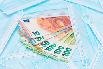 Euro Banknotes with Blue Disposable Medical Face Masks. Trade in Medical Masks. Business During a Pandemic or Epidemic