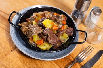 Appetizing beef stew served with potatoes and mushrooms on platter