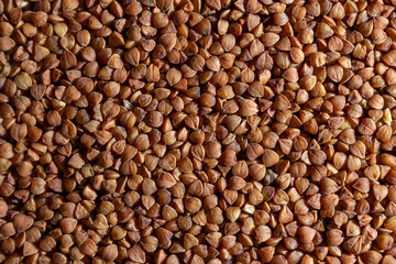 Dry Uncooked Brown Buckwheat Groats Background - Top View, Flat Lay. Raw Large Buckwheat Grains. Russian, Ukrainian and Belarusian Culture