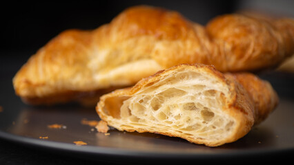 Freshly Baked Flaky Butter Croissant and Coffee on Dark Plate