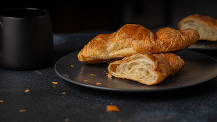 Freshly Baked Flaky Butter Croissant and Coffee on Dark Plate