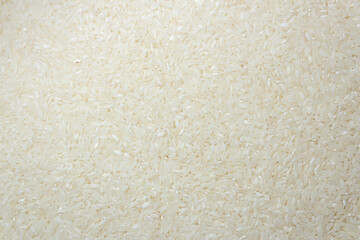 Dry Uncooked White Rice Background - Top View, Flat Lay. Scattered Raw Long Grain Rice. Asian Cuisine and Culture. Healthy Eating Ingredients. Diet Food