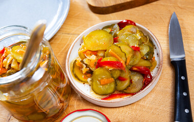 Pickled cucumbers and bell peppers in a glass jar