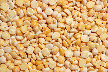 Uncooked Polished Split Peas Background. A Culinary Canvas of Dry Yellow Peas, Creating a Lively and Textured Background for Gourmet Cooking. Scattered Raw Polished Peas. Healthy Eating Ingredients