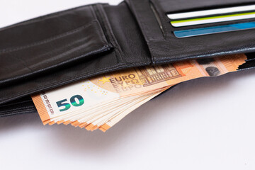 Opened Black Leather Men Wallet with Fifty Euro Banknotes and Bank Cards Inside on White Background. A Purse Full of Money and Credit Cards Symbolizing Wealth, Success and Social Status