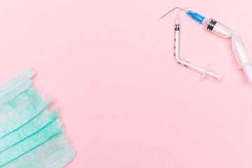 Anti Vaccine Movement and Anti Mask Concept - Broken Medical Syringe and Green Torn Medical Face Mask on the Pink Background. Pandemic and Lockdown End - Top View, Flat Lay