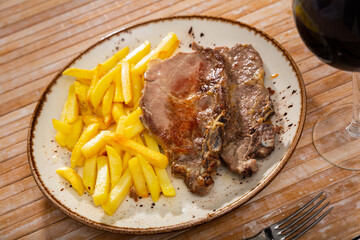 Grilled barbecue pork meat with baked potato and dip on a plate