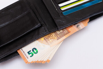 Opened Black Leather Men Wallet with Fifty Euro Banknotes and Bank Cards Inside on White Background. A Purse Full of Money and Credit Cards Symbolizing Wealth, Success and Social Status