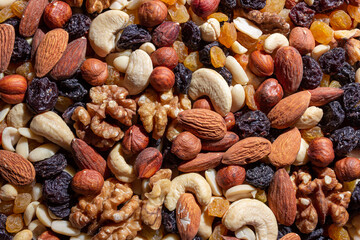Mixed Nuts: Almonds, Walnuts, Cashews, Peanuts, Hazelnuts, Dried Prunes and Raisins. Different Nut Mix. Background from Various Nuts and Dried Fruits