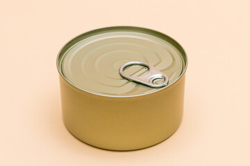 Unopened Tin Can with Blank Edge on Beige Background. Canned Food. Aluminum Can for Safe and Long Term Storage of Food. Steel Sealed Food Storage Container
