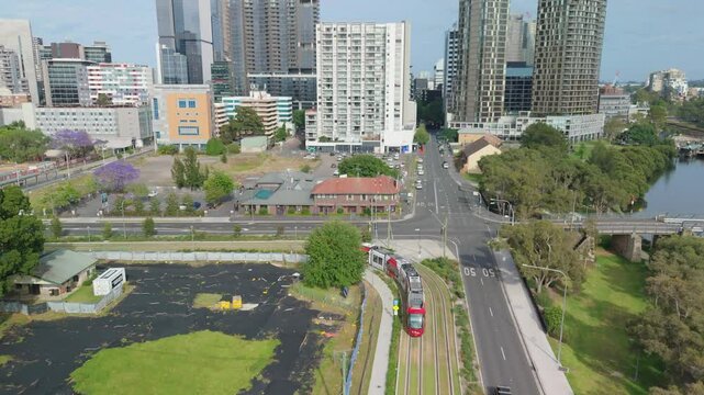 Aerial drone view of a light rail vehicle at Parramatta cbd in Western Sydney, NSW, Australia as it turns onto Harris Street in November 2024 