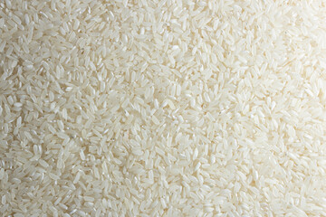 Dry Uncooked White Rice Background - Top View, Flat Lay. Scattered Raw Long Grain Rice. Asian Cuisine and Culture. Healthy Eating Ingredients. Diet Food