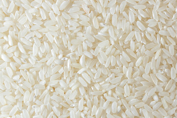 Dry Uncooked White Rice Background - Top View, Flat Lay. Scattered Raw Long Grain Rice. Asian Cuisine and Culture. Healthy Eating Ingredients. Diet Food