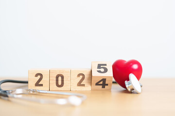 2024 end year to Happy New Year 2025 with Stethoscope of doctor and heart shape on table. health...