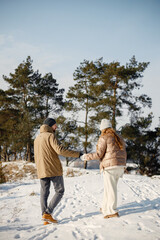 Young man and woman spending time together at winter day
