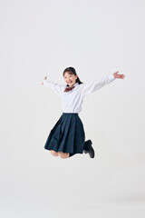 白背景,笑顔でジャンプをする日本人女子中学生