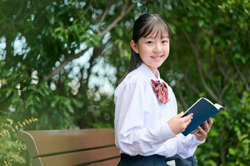 公園で本を読む女子中学生