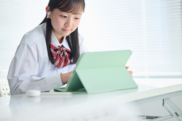 タブレット端末で授業を受ける女子中学生