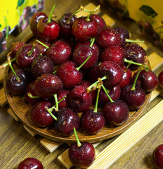 Freshly Washed Cherries with Water Droplets on a Wooden Plate