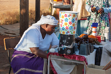 african street vendor selling cow bell and buckets, art and craft products, small entrepreneur...