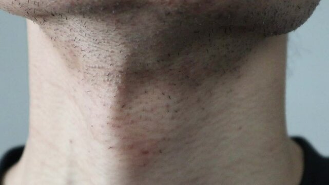 つばを飲み込む男性の首元