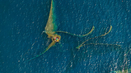 Fishermen spread nets to catch fish at Chan May beach, Hue, in the middle of the vast sea and the turquoise water is truly beautiful. Photo taken in Hue on June 25, 2023.	
