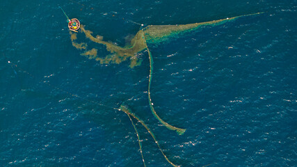 Fishermen spread nets to catch fish at Chan May beach, Hue, in the middle of the vast sea and the turquoise water is truly beautiful. Photo taken in Hue on June 25, 2023.	