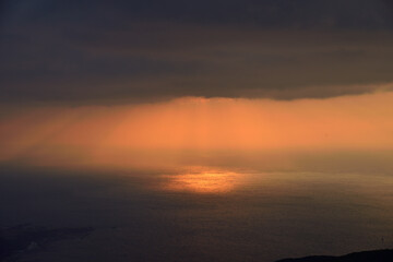 Sunset reflected on the sea Angel's ladder Crepuscular rays /...