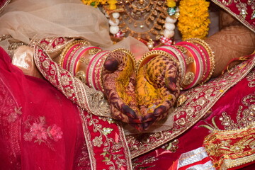 Indian Bride wearing beautiful Red Lehenga in her marriage, Human hand decorated with henna tattoo...