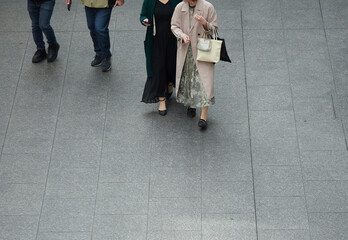 ハイアングルで撮影した冬の繁華街で歩く美しい中年女性の姿