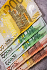 A collection of Euro banknotes in various denominations, showcasing their unique designs and differences