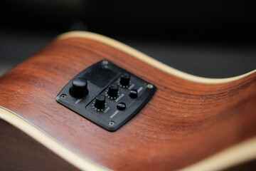 Close up shot of acoustic guitar pickup EQ with tuner.