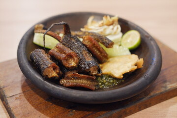 Javanese cuisine, grilled eel and pickled cucumber on plate